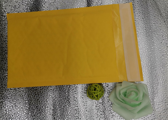 노란 크라프트 지는 포장 백을 패드를 댔고 버블 우편물발송자 백을 감쌉니다
